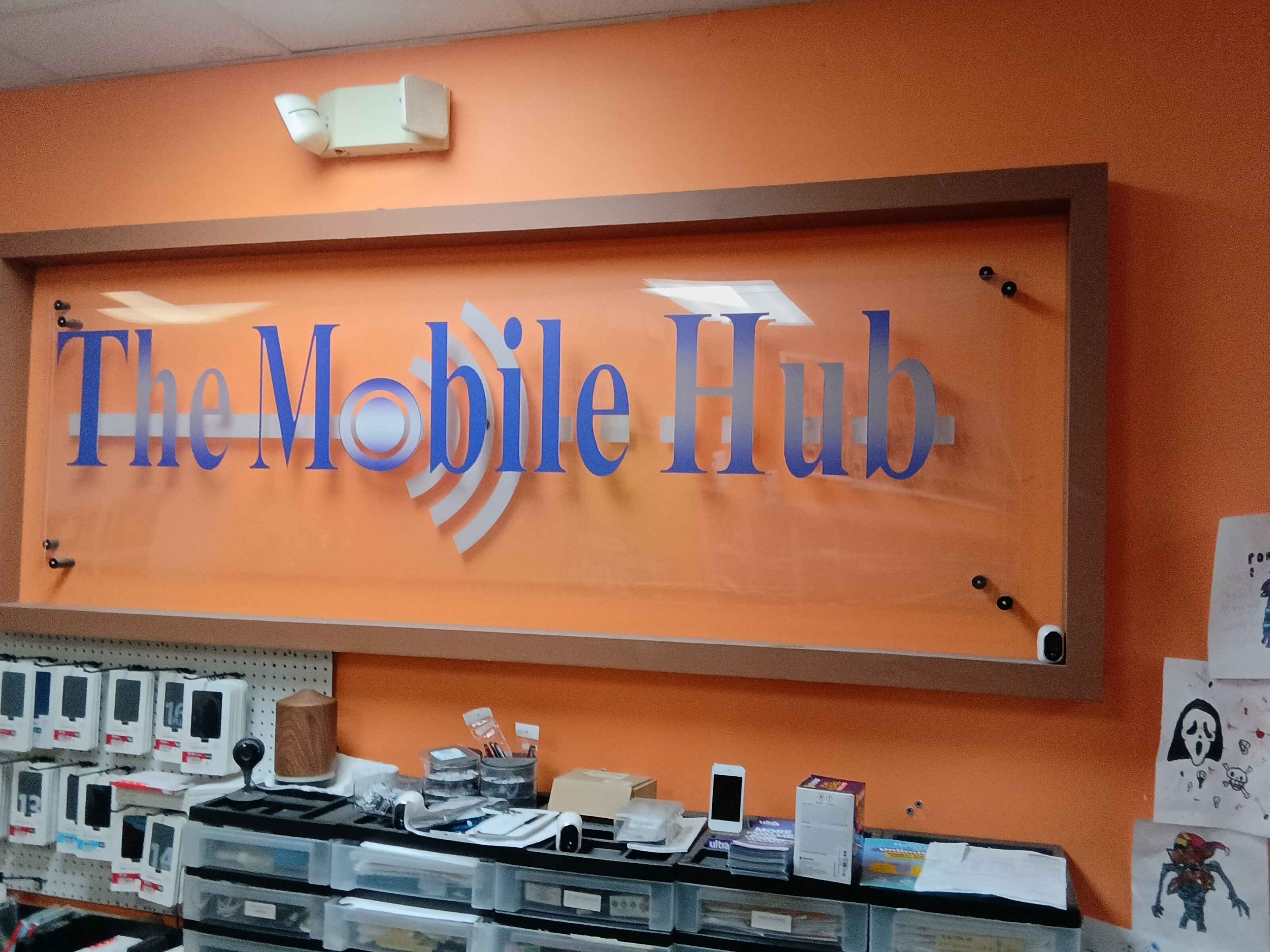 The Mobile Hub sign on the orange wall at 4879 Okeechobee Blvd
